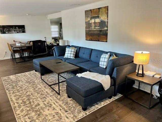 A living room features a blue sectional sofa, a coffee table, and a dining area — 325 S 2ND STREET UNIT 206, LEESBURG, FL