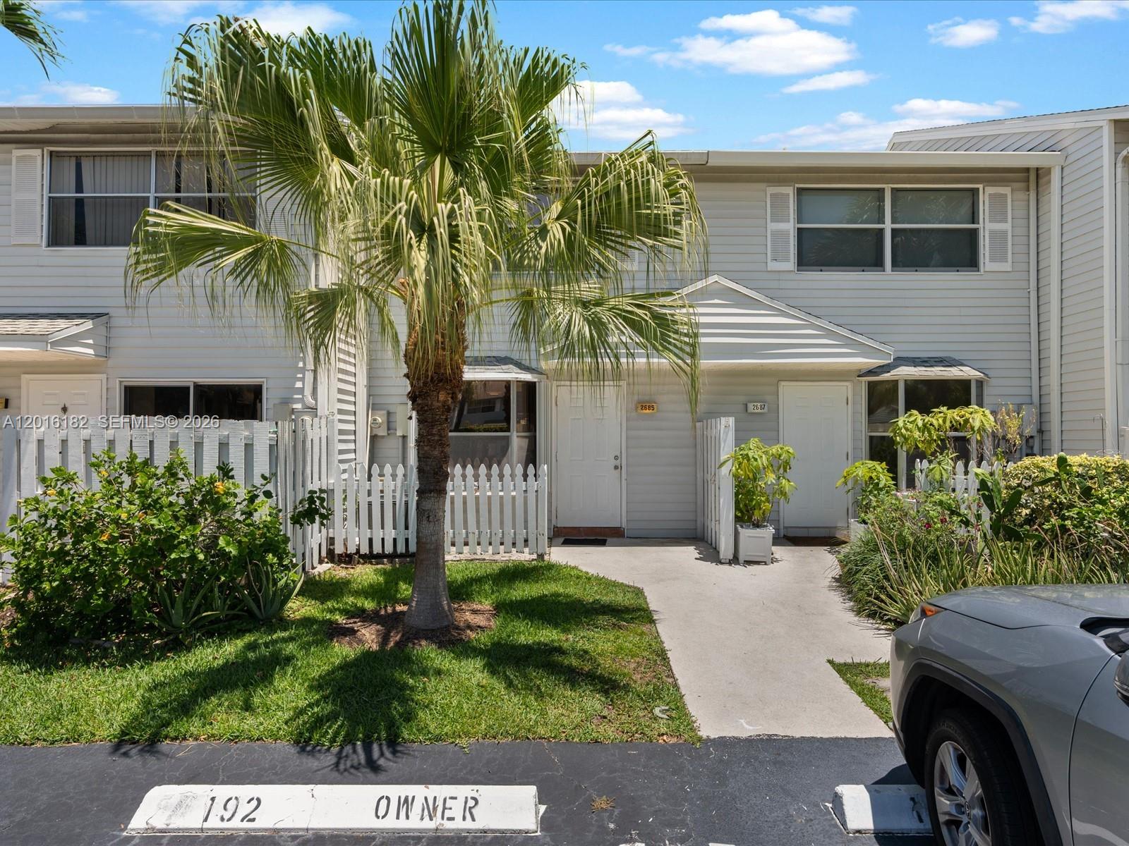 A two-story townhouse exterior features light siding, a palm tree, and a concrete walkway — 2685 NE 15th St, Pompano Beach FL 33062, POMPANO BEACH, FL