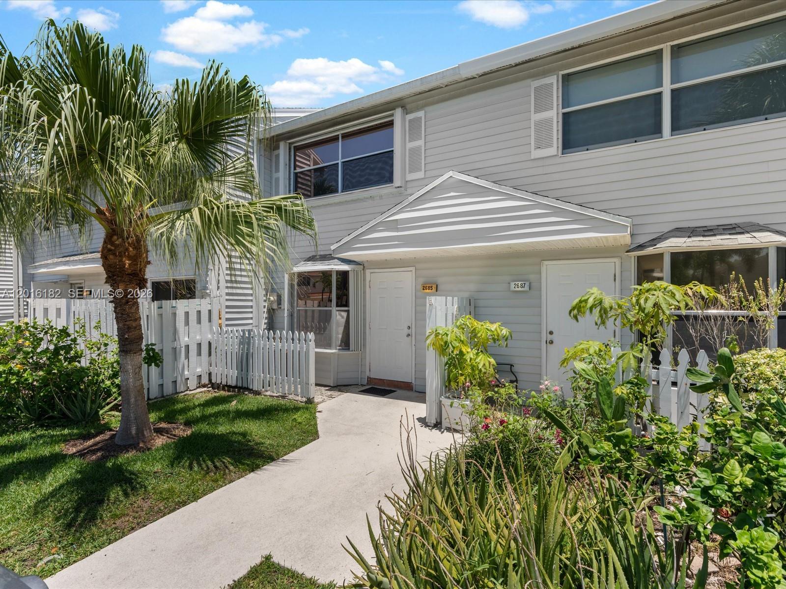 A two-story townhouse exterior features light gray siding, white trim, and a small front garden — 2685 NE 15th St, Pompano Beach FL 33062, POMPANO BEACH, FL