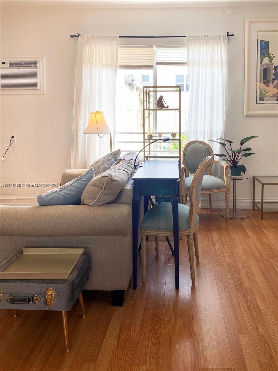 A living room features a sofa, a console table with chairs, and a window with curtains — 820 Euclid Ave # 203, Miami Beach FL 33139, MIAMI BEACH, FL