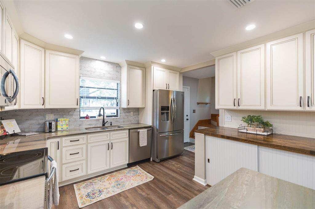 A kitchen with white cabinets, stainless steel appliances, and a wood countertop peninsula — 702 W BAY STREET UNIT A, TAMPA, FL
