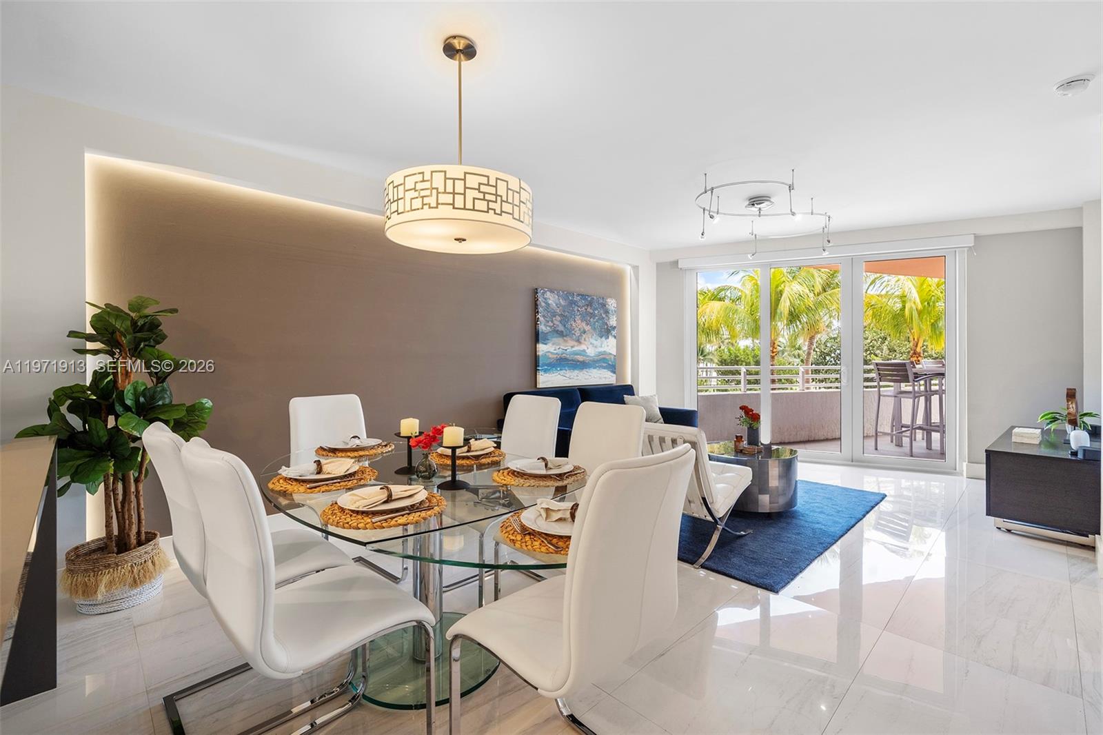 A dining and living area features a glass table, white chairs, and a balcony view — 226 Ocean Dr # 3C, Miami Beach FL 33139, MIAMI BEACH, FL