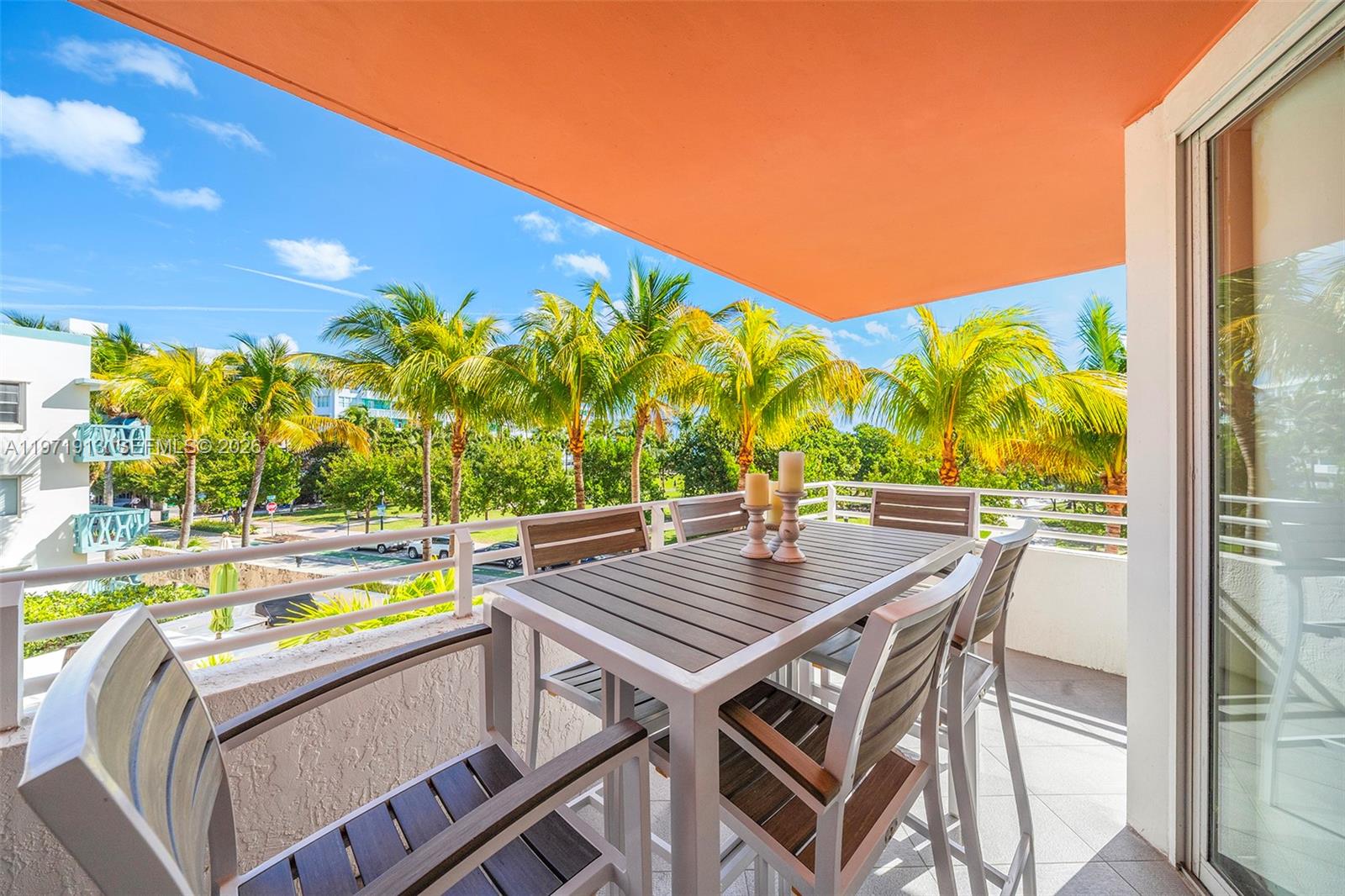A balcony features a dining set with four chairs overlooking palm trees and a street — 226 Ocean Dr # 3C, Miami Beach FL 33139, MIAMI BEACH, FL