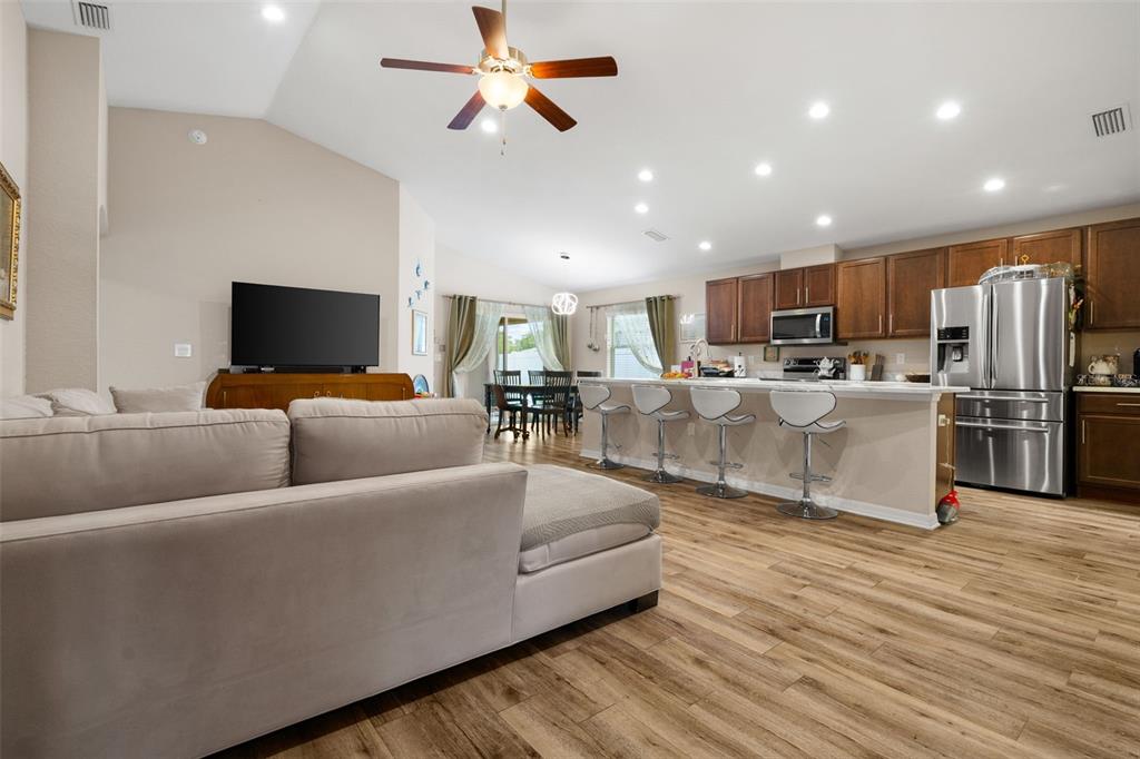 A living room features a beige sectional sofa, a wooden coffee table, and a television console — 2014 DANES COURT, LAKELAND, FL