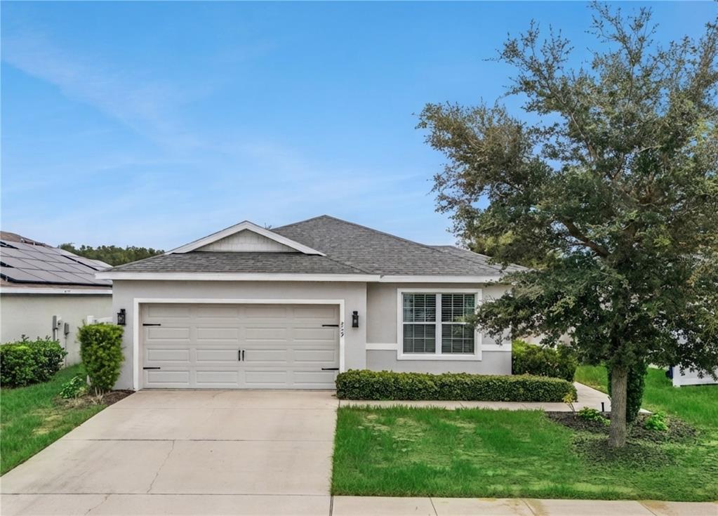 A single-story house with a gray stucco exterior, a two-car garage, and a front lawn — 229 SANDESTIN DR, HAINES CITY, FL