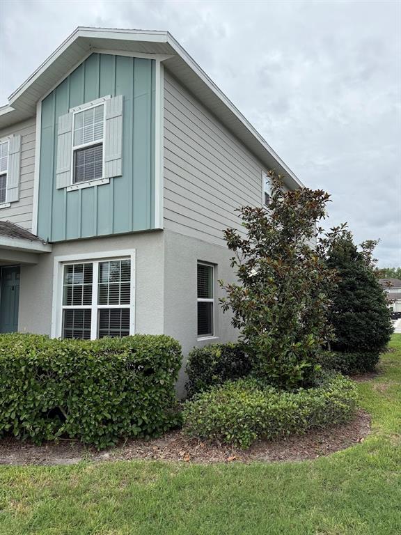 A kitchen features white cabinets, granite countertops, a central island, and three rattan bar stools — 15084 CARAVAN AVENUE, ODESSA, FL