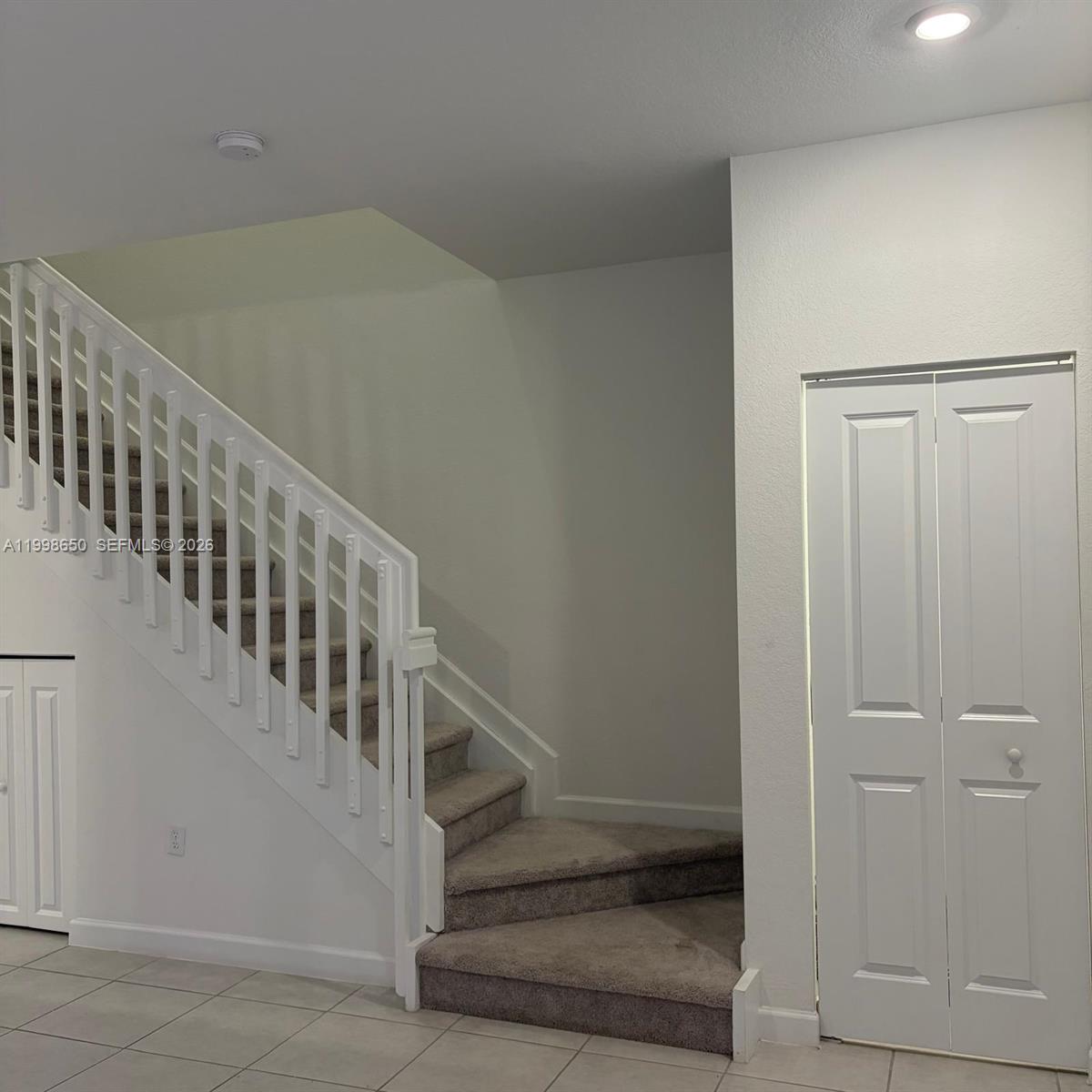 A carpeted staircase with a white railing stands next to a white closet door — 23320 SW 127th Ct, Homestead FL 33032, HOMESTEAD, FL