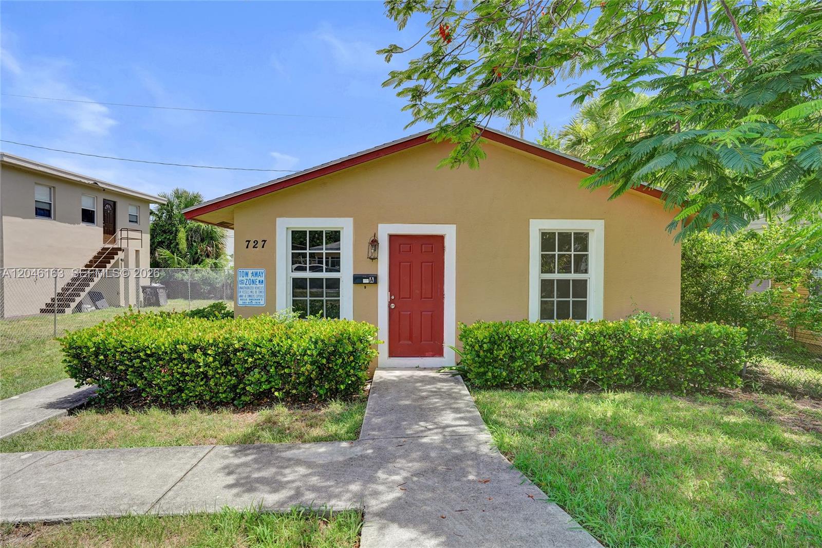 A single-story tan house with a red front door and a concrete walkway — 727 22nd St # A, West Palm Beach FL 33407, WEST PALM BEACH, FL