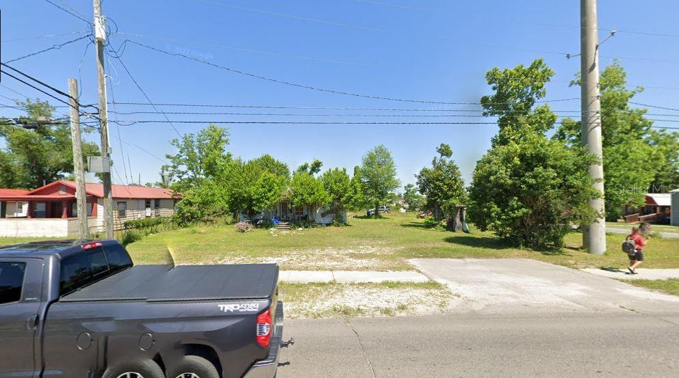 A vacant grassy lot sits between a house on the left and trees on the right — 242 N HIGHWAY 22 A, PANAMA CITY, FL