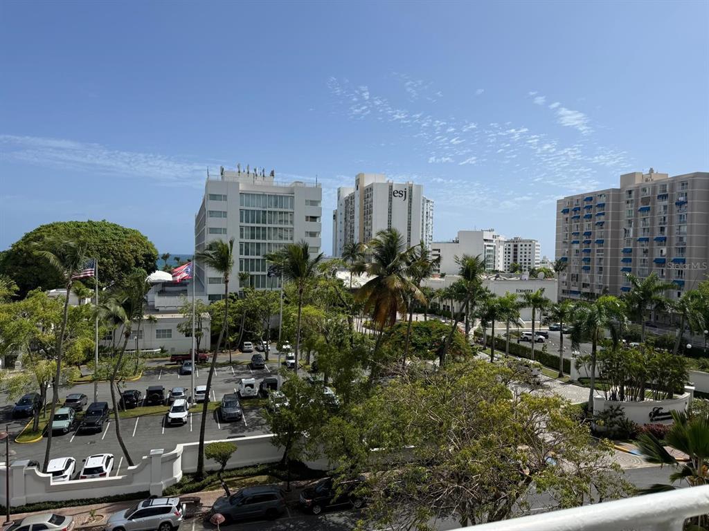 An elevated view of a parking lot surrounded by palm trees and high-rise buildings — 6400 ISLA VERDE AVENUE UNIT 5D, CAROLINA, PR