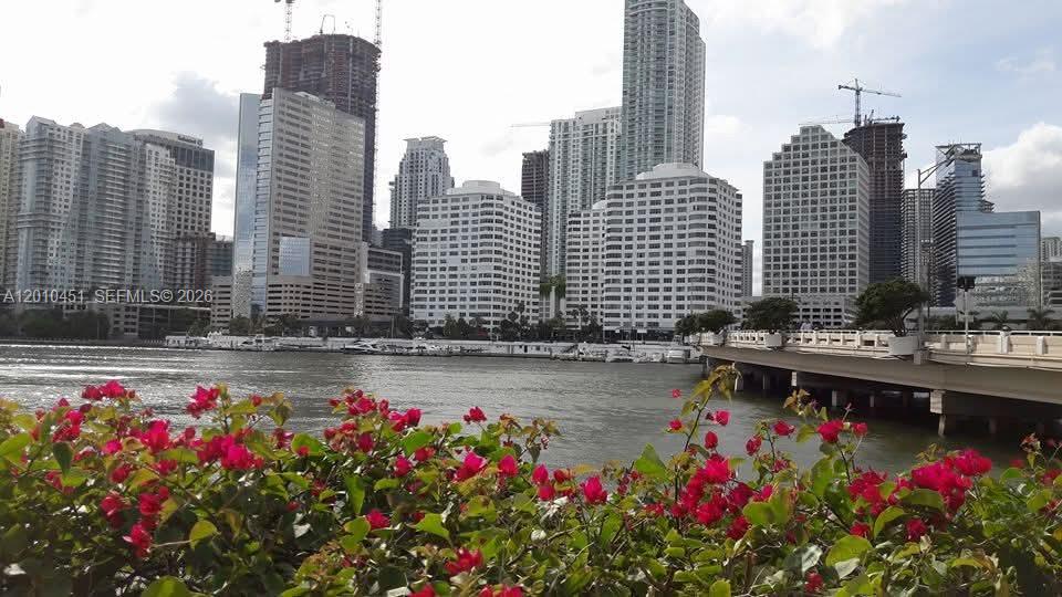 A view of the Miami skyline across the water with a bridge and foreground flowers — 999 Brickell Bay Dr # 805, Miami FL 33131, MIAMI, FL