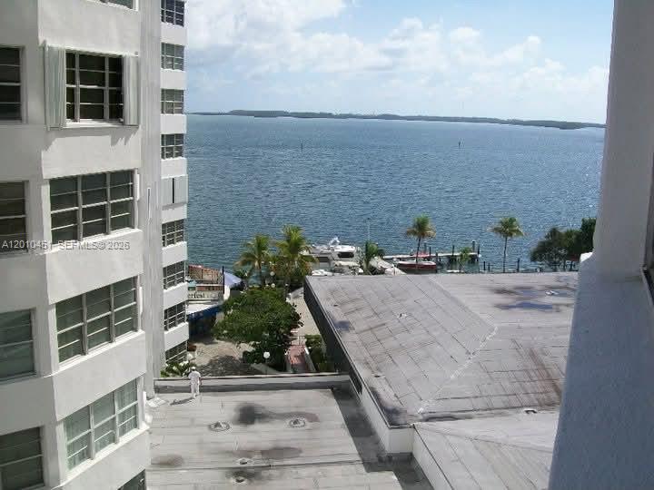 An elevated view shows a building exterior, a flat roof, palm trees, and the ocean — 999 Brickell Bay Dr # 805, Miami FL 33131, MIAMI, FL