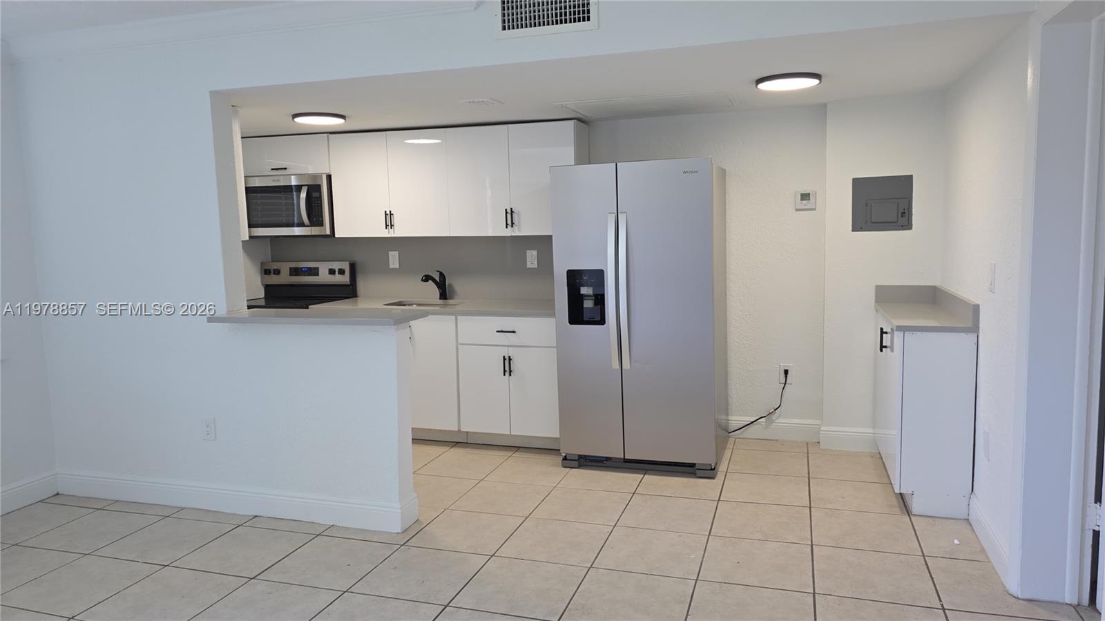 A bathroom features a wood vanity, a round mirror, a toilet, and a tiled shower — 3901 SW 112th Ave # 38, Miami FL 33165, MIAMI, FL