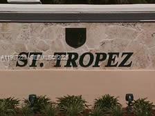 A stone wall features the black lettering ST. TROPEZ and a shield emblem above landscaping — 6731 NW 107th Ct # 6731, Doral FL 33178, DORAL, FL