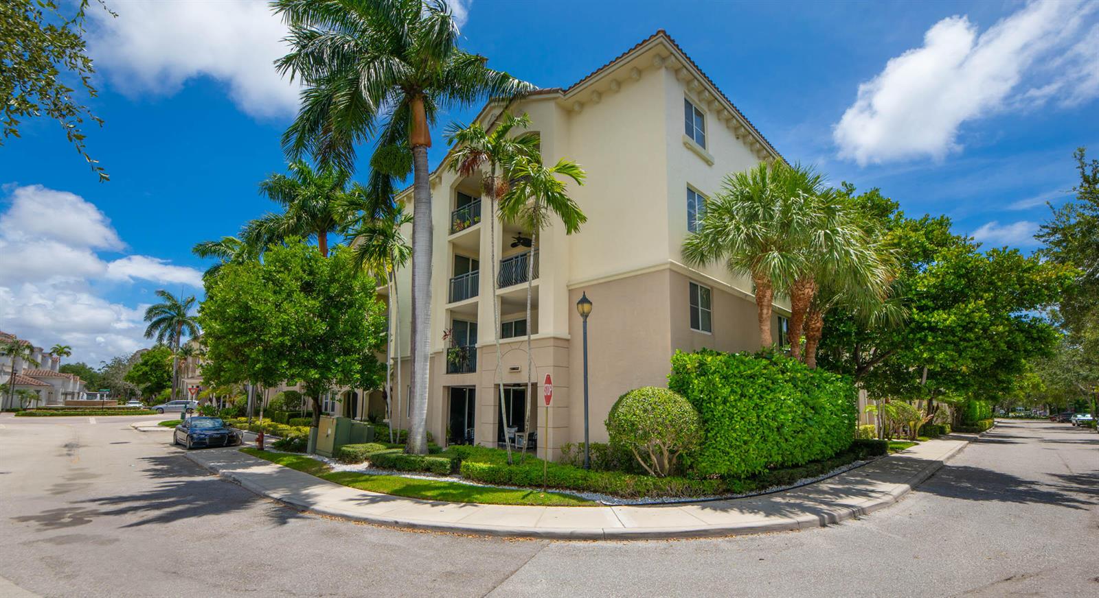 A multi-story apartment building with balconies, palm trees, and a landscaped hedge on a corner — 3107 Renaissance Way, Boynton Beach FL 33426, BOYNTON BEACH, FL