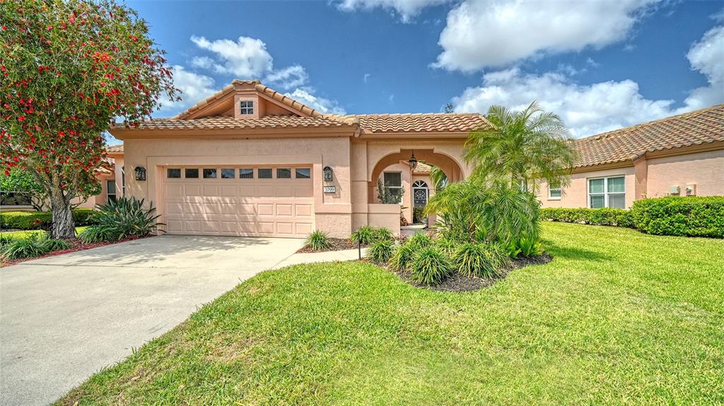 A single-story stucco house with a tile roof, two-car garage, and a landscaped front yard — 3799 MIRA LAGO DRIVE, SARASOTA, FL