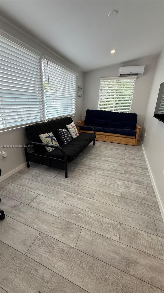 A living room features light wood-look flooring, two futons, and white window blinds — 65821 Overseas Hwy # 314, Long Key FL 33001, LONG KEY, FL