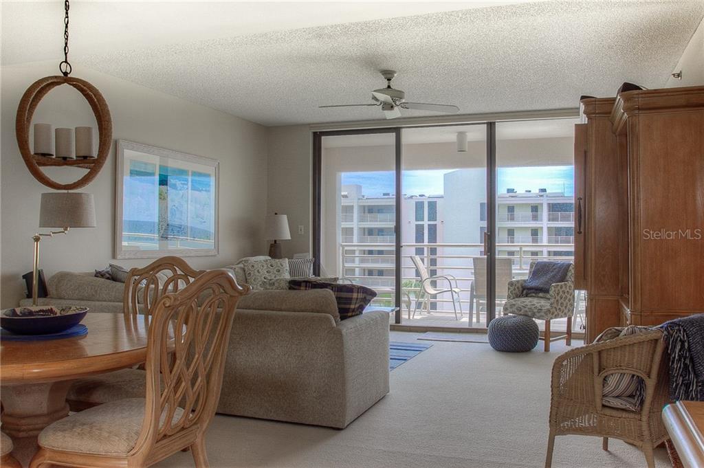 A living and dining area features a sliding glass door leading to a balcony — 2109 GULF OF MEXICO DRIVE UNIT 1402, LONGBOAT KEY, FL