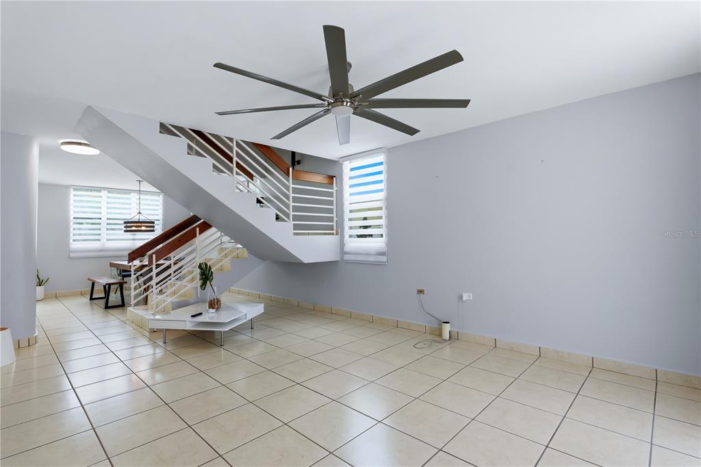 A living area features a staircase with white railings, tile flooring, and a ceiling fan — B-3 EVEREST, TOA ALTA, PR