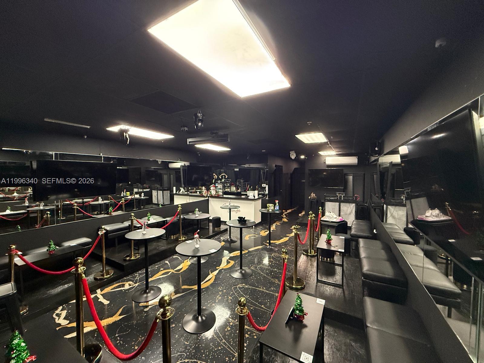 A lounge area features black walls, mirrored surfaces, pedestal tables, and red velvet stanchion ropes — 303 NE 3rd AVE, Cape Coral FL 33909, CAPE CORAL, FL