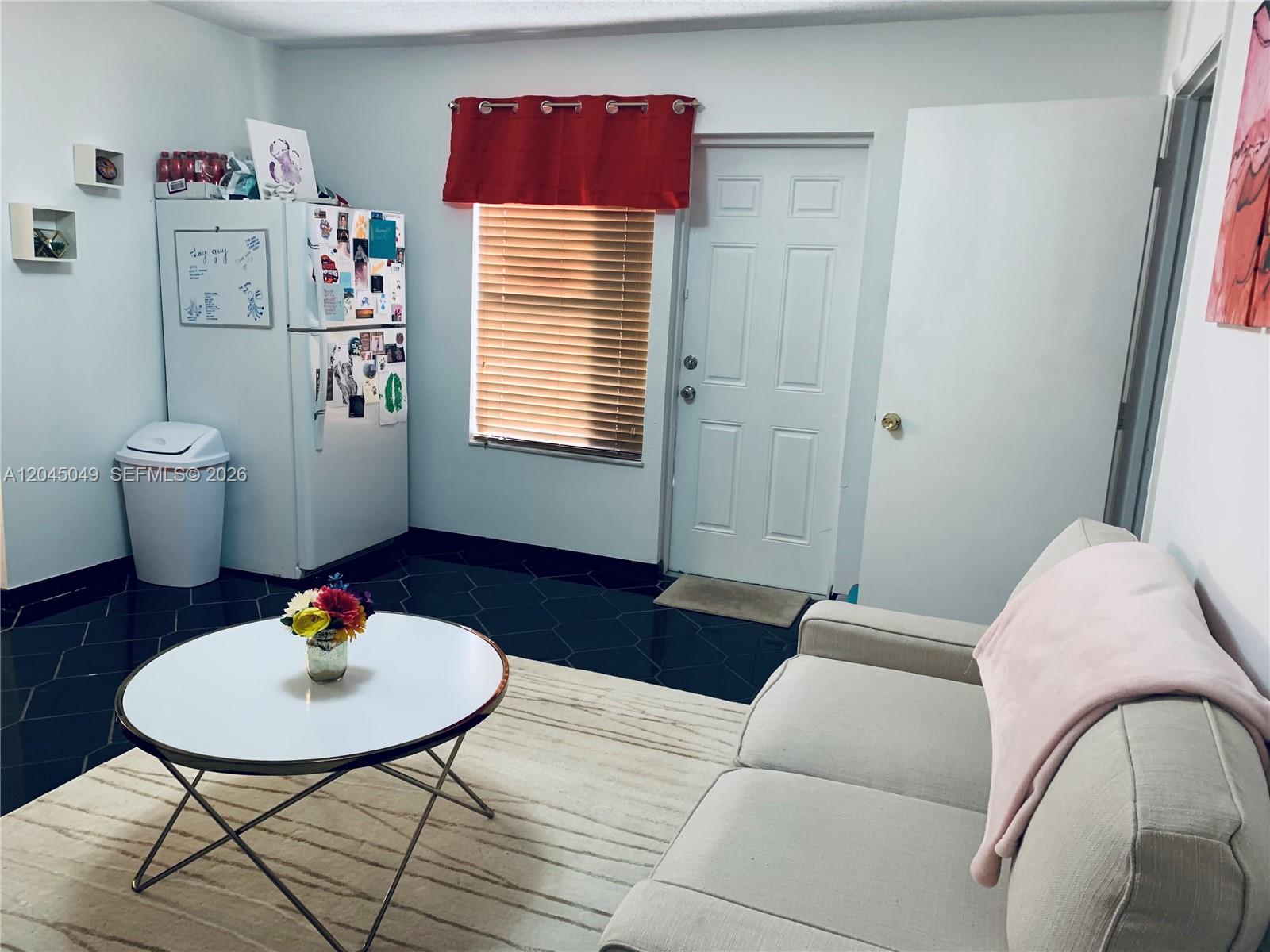 A living room features a white sofa, a round coffee table, and a refrigerator — 11230 SW 138th St # A, Miami FL 33176, MIAMI, FL