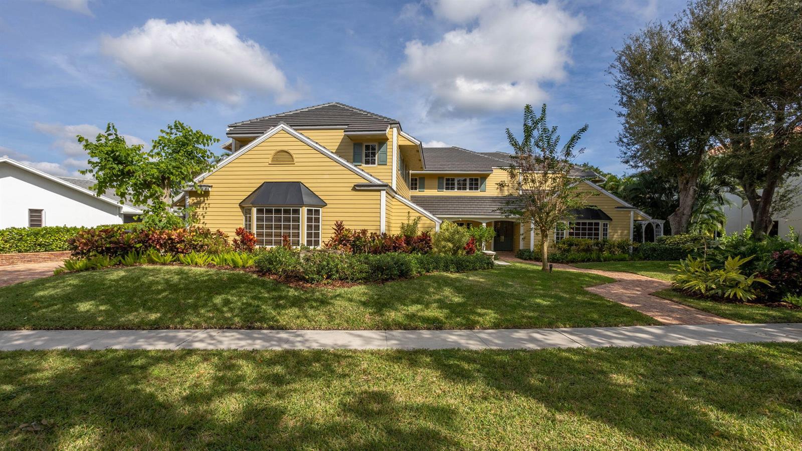A two-story yellow house with a dark shingled roof and a brick walkway — 2883 Banyan Boulevard Circle NW, Boca Raton FL 33431, BOCA RATON, FL