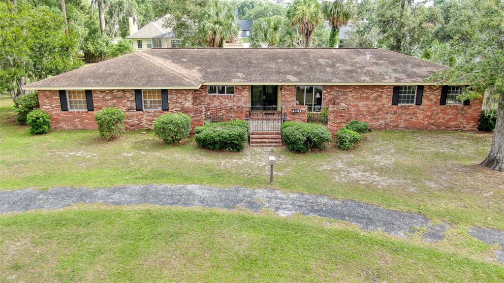 A single-story brick house with a dark shingled roof and a curved driveway — 4243 SE 8TH STREET, OCALA, FL