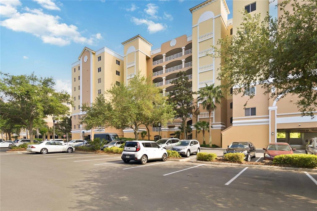 A multi-story apartment building with a parking lot in the foreground — 6336 BUFORD STREET UNIT 209, ORLANDO, FL