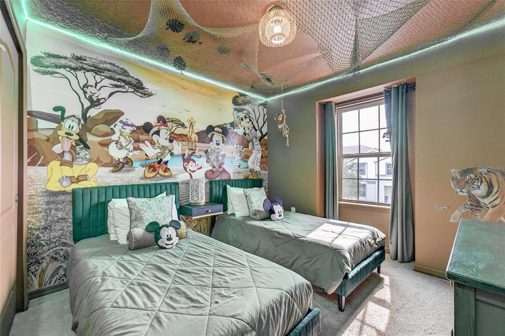 A themed bedroom features two twin beds, a large Disney safari mural, and ceiling netting — 2417 DUBAI STREET, KISSIMMEE, FL