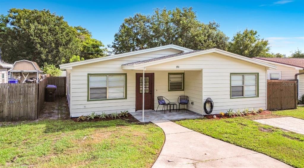 A kitchen features white cabinets, wood countertops, stainless steel appliances, and a tiled backsplash — 1911 SUNNY STREET, KISSIMMEE, FL