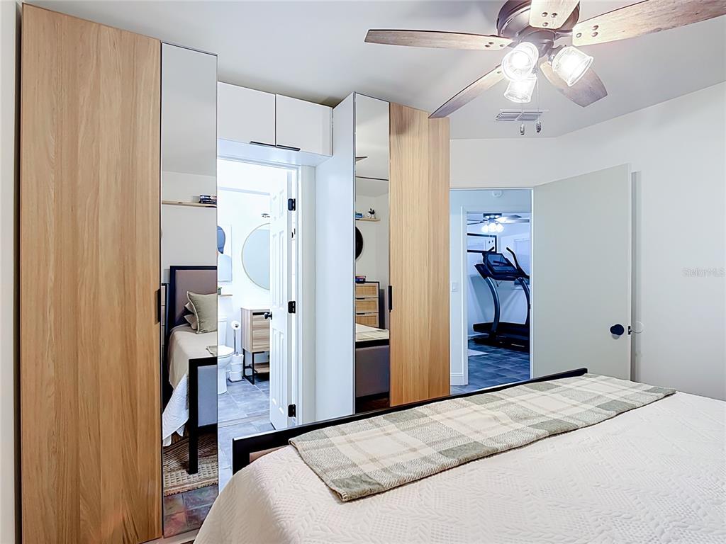 A kitchen with white cabinets, wood countertops, stainless steel appliances, and gray tiled flooring — 1911 SUNNY STREET, KISSIMMEE, FL
