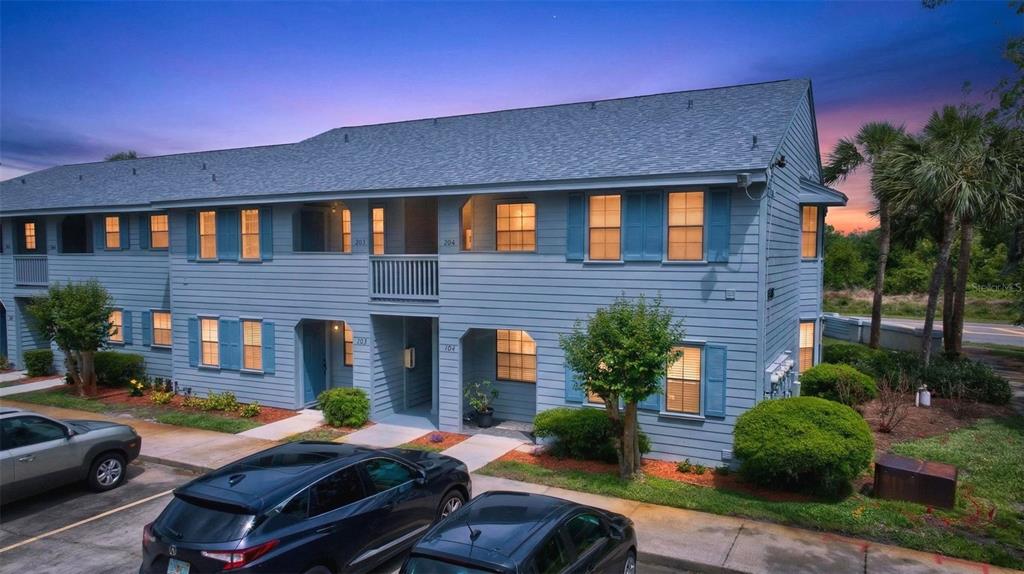 A two-story blue apartment building with a shingled roof and parked cars in front — 1765 HARRISON STREET UNIT 204, TITUSVILLE, FL