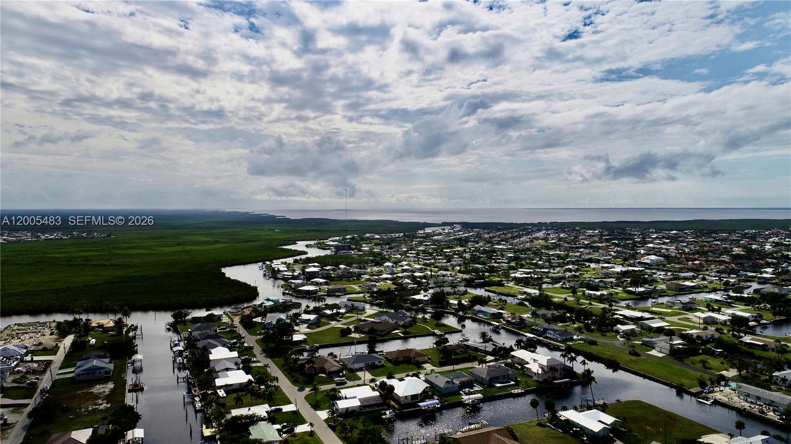 An aerial view shows a residential neighborhood with houses situated along canals near wetlands — 4114 PALM, Punta Gorda FL 33950, PUNTA GORDA, FL