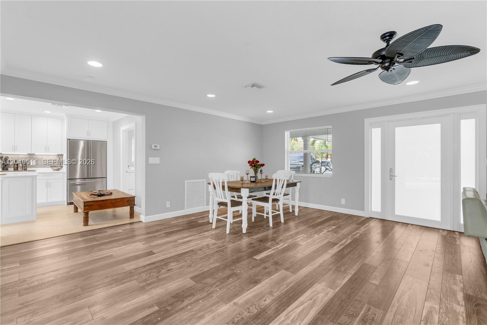 A dining area with wood-look flooring, a ceiling fan, and an adjacent kitchen — 1405 SW 4th Ter, Pompano Beach FL 33060, POMPANO BEACH, FL