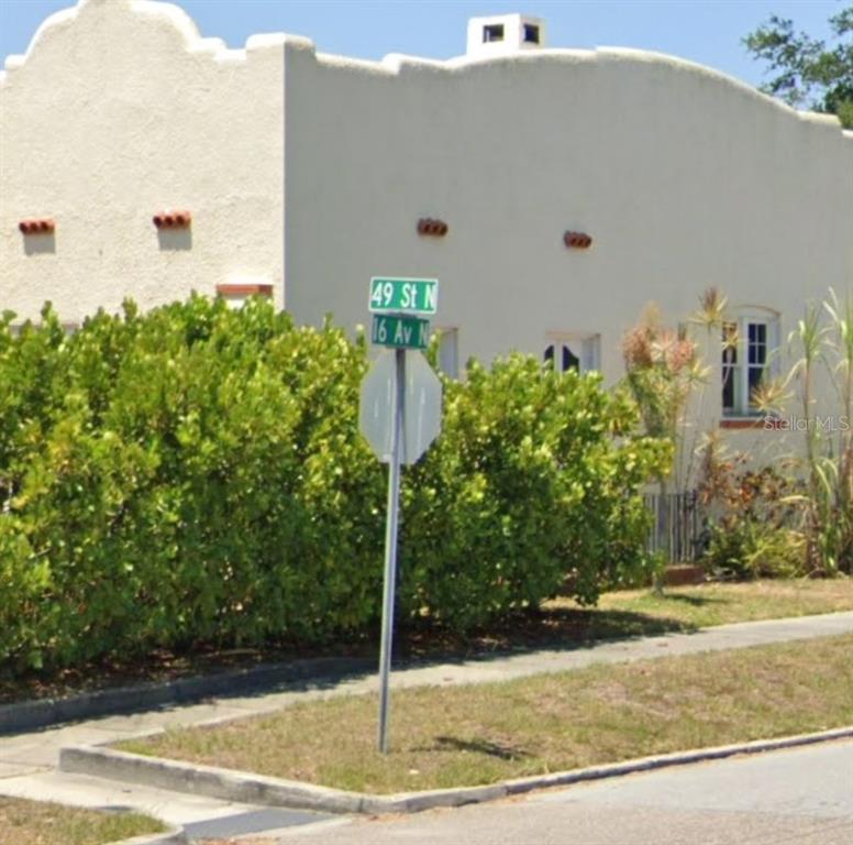 A street sign stands in front of a stucco building with a curved roofline — 000 16TH AVENUE N, ST PETERSBURG, FL
