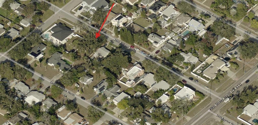An aerial map view showing a residential neighborhood with a red arrow pointing to a lot — 000 16TH AVENUE N, ST PETERSBURG, FL