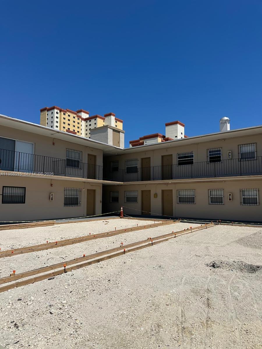 An exterior view of a two-story apartment building with a gravel courtyard under construction — 100 NE 78th St # 4, Miami FL 33138, MIAMI, FL