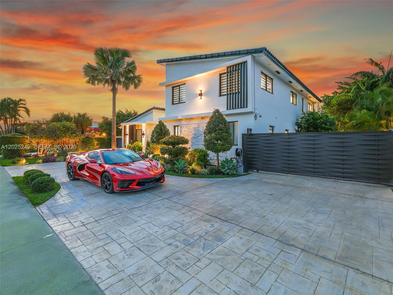 A red sports car is parked on a paved driveway in front of a modern house — 8761 SW 56th St, Miami FL 33165, MIAMI, FL