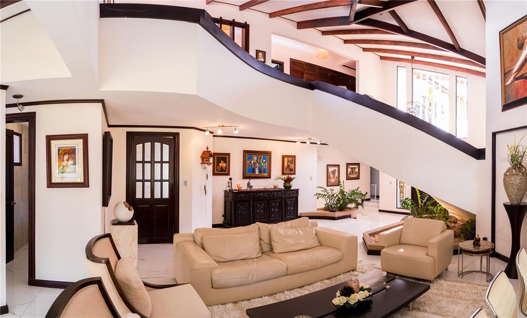 A spacious living room features a beige sofa, dark wood staircase, and white tile floors — 84 URBANIZACION DE RIO ORO, SANTA ANA, OC