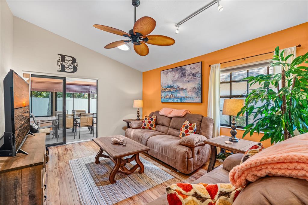 A living room features brown sofas, a wooden coffee table, and an orange accent wall — 4523 NETTLE CREEK COURT, PORT ORANGE, FL