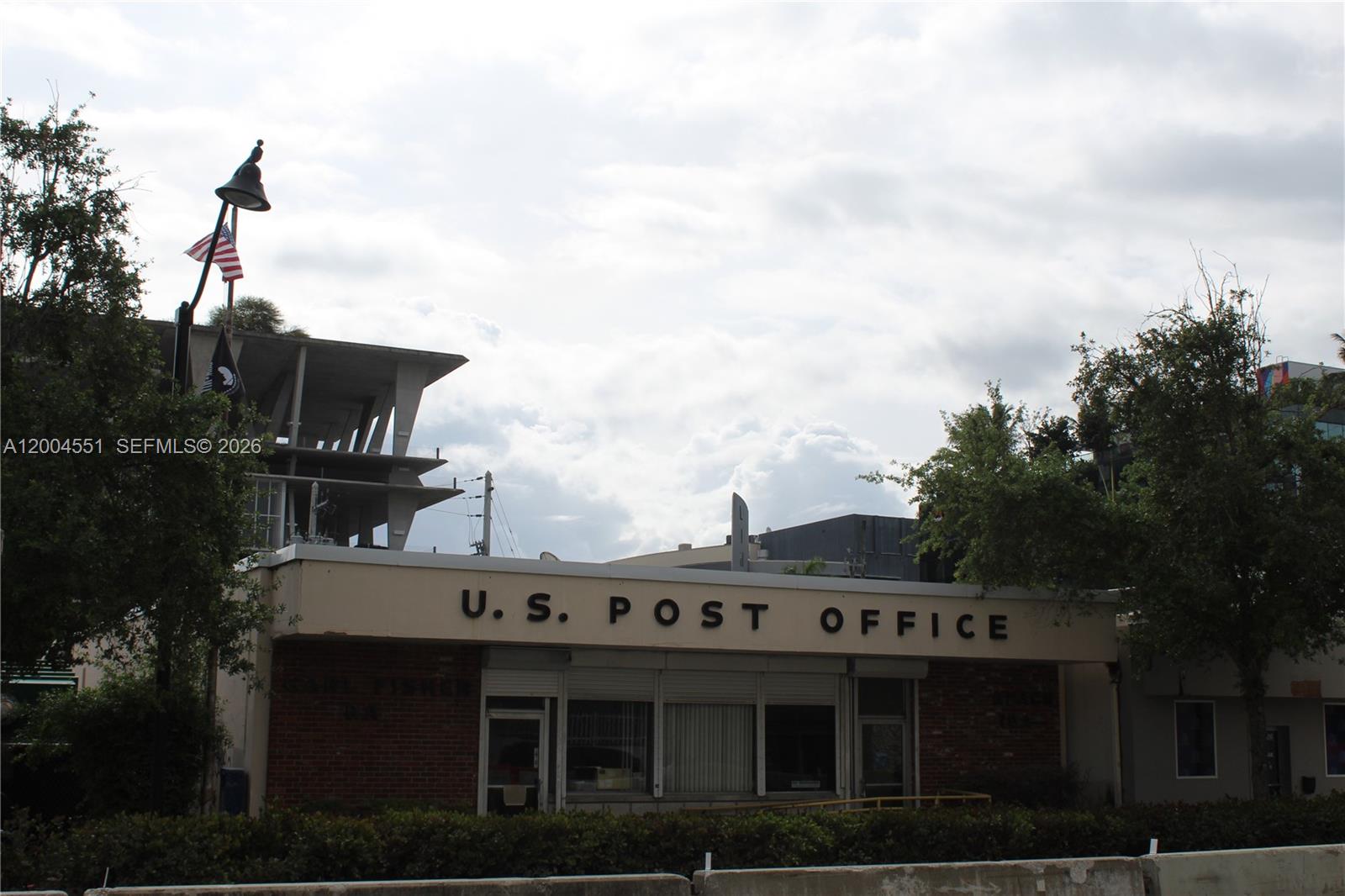 A U.S. Post Office building with a brick facade stands beneath a cloudy sky — 1661 West Ave, Miami Beach FL 33139, MIAMI BEACH, FL