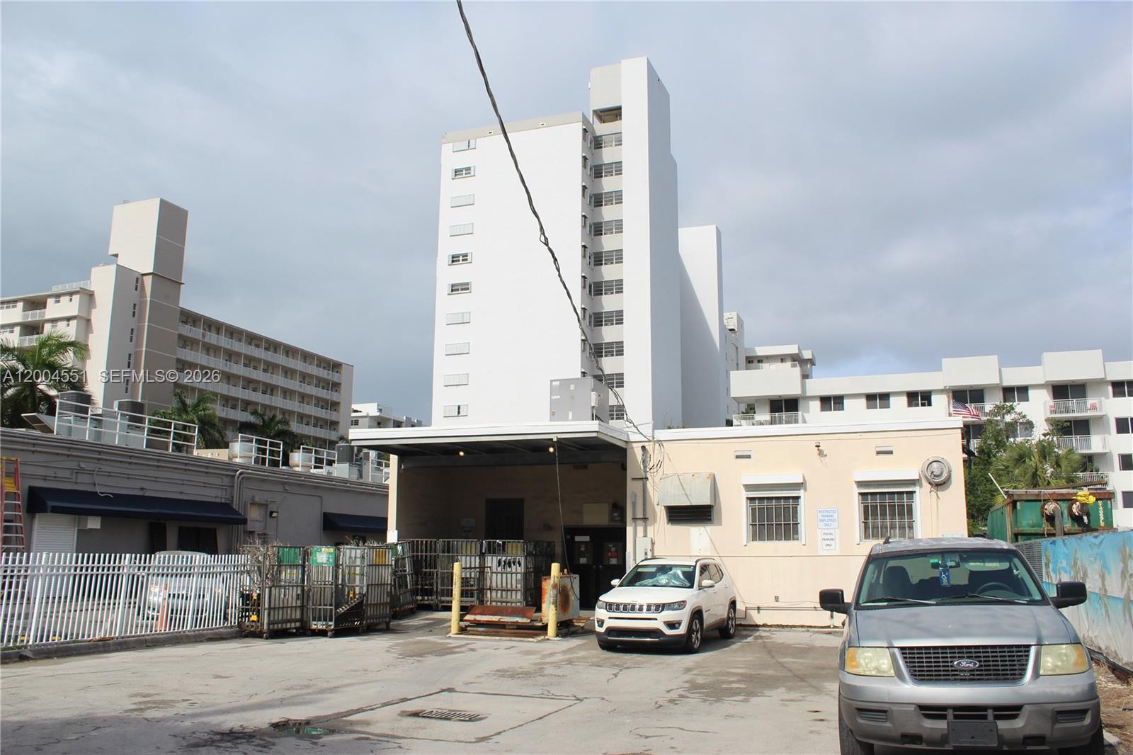 An exterior view shows a parking lot in front of a multi-story white building — 1661 West Ave, Miami Beach FL 33139, MIAMI BEACH, FL