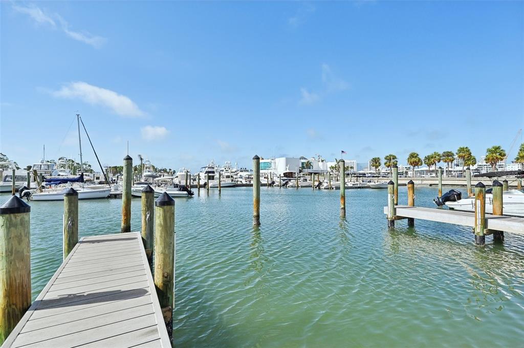 A wooden dock extends into a marina filled with various boats under a blue sky — 1771 RINGLING BOULEVARD UNIT 1001, SARASOTA, FL