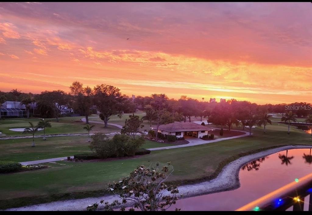 An elevated view of a golf course at sunset with a pond and small building — 6100 GULFPORT BOULEVARD S UNIT 401, GULFPORT, FL