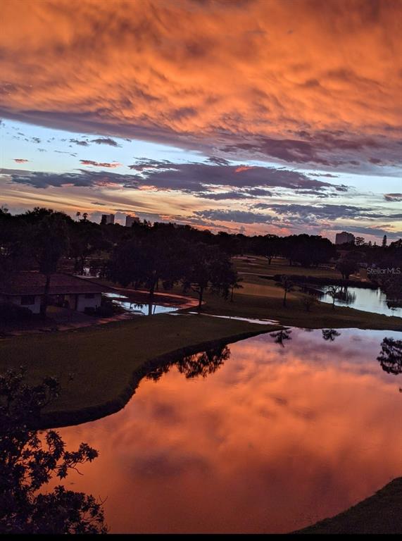 A sunset reflects over a pond and golf course with buildings in the distance — 6100 GULFPORT BOULEVARD S UNIT 401, GULFPORT, FL