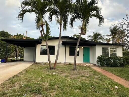 A room with green walls, wood-look flooring, and an open doorway to a sunroom — 720 S 11th Street, Lantana FL 33462, LANTANA, FL