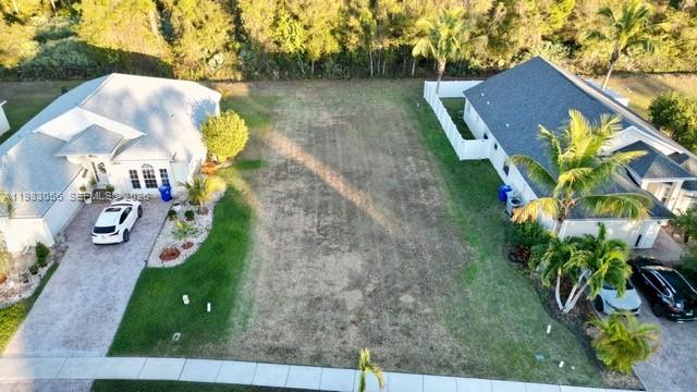 An aerial view shows a vacant residential lot situated between two houses — 1570 SW 16th Ct SW, Vero Beach FL 32962, VERO BEACH, FL