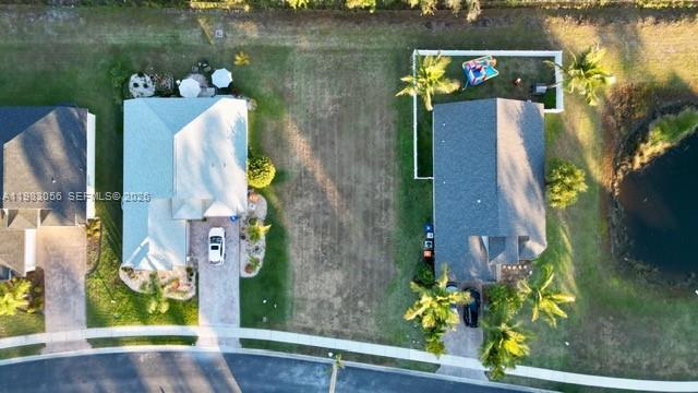An aerial view shows two houses separated by a vacant lot near a small pond — 1570 SW 16th Ct SW, Vero Beach FL 32962, VERO BEACH, FL