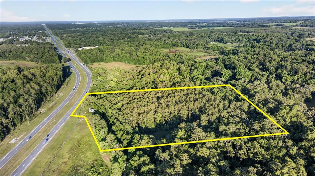 An aerial view shows a rectangular plot of land outlined in yellow next to a highway — 0 CORTEZ BLVD, BROOKSVILLE, FL