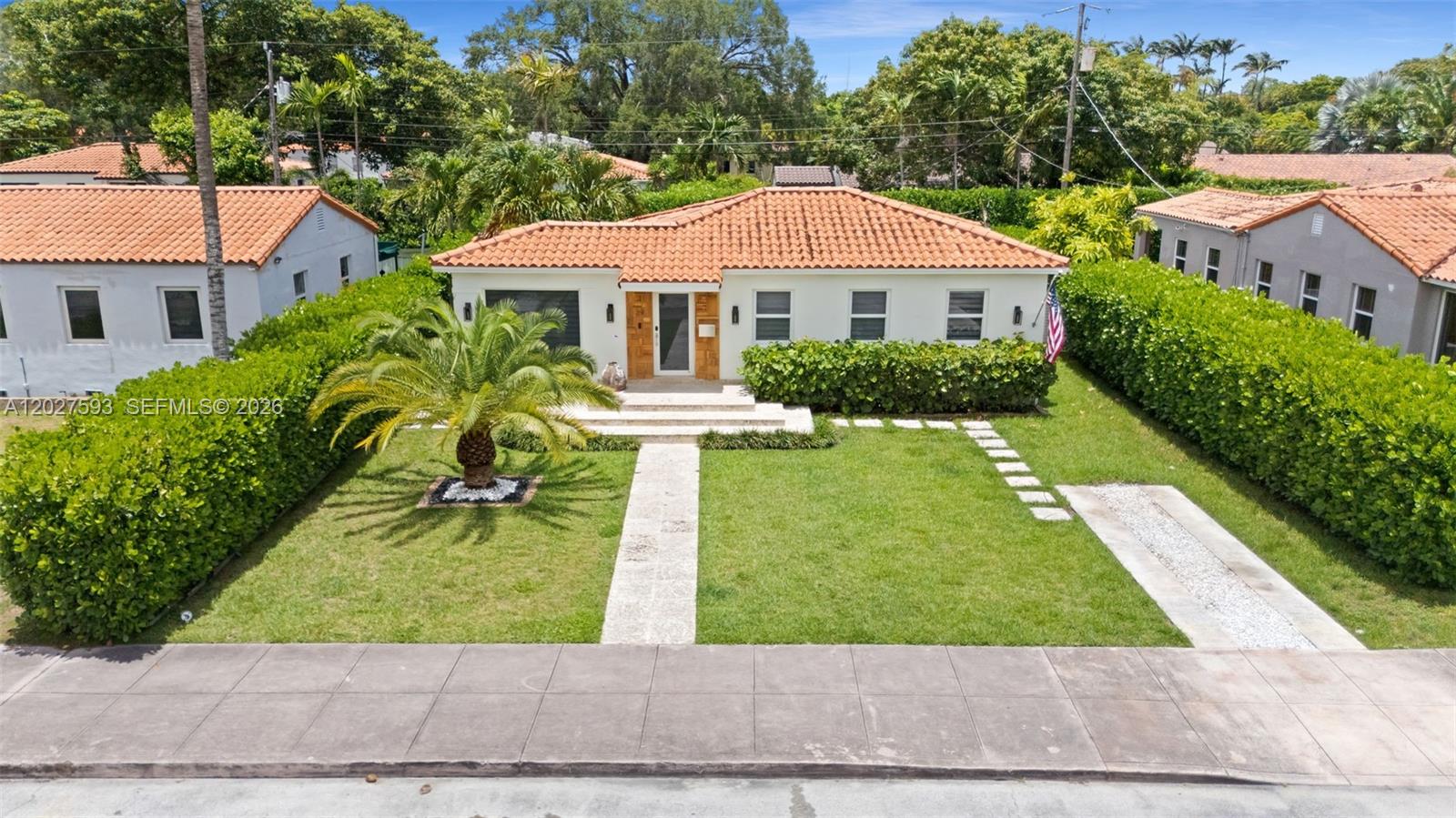 A single-story house with a terracotta tile roof sits behind a manicured lawn and hedge — 39 Montilla Ave, Coral Gables FL 33134, CORAL GABLES, FL